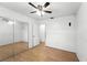 Bedroom with wood-look floors, ceiling fan, closet, and a door leading outside of the room at 1116 W Kirby St, Tampa, FL 33604