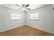 This bedroom has wood-look flooring, two windows with blinds, and a ceiling fan at 1116 W Kirby St, Tampa, FL 33604