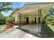Home exterior featuring a covered carport with decorative metal supports and a brick facade at 1116 W Kirby St, Tampa, FL 33604