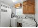 Functional laundry area includes a washing machine, dryer, sink, and overhead storage at 1116 W Kirby St, Tampa, FL 33604