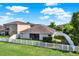 Well-maintained backyard featuring a white picket fence, green lawn, and a screened lanai for outdoor enjoyment at 11309 Langworth Hill Ln, Riverview, FL 33579