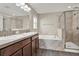 Bright bathroom featuring double sinks, separate bathtub, shower, and glass door at 11309 Langworth Hill Ln, Riverview, FL 33579