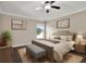 Bedroom with a ceiling fan, wood floors, natural light, and framed art hanging on the walls at 11309 Langworth Hill Ln, Riverview, FL 33579