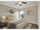 Bedroom with hardwood flooring, a neutral color palette, ceiling fan, and an exterior view through a window at 11309 Langworth Hill Ln, Riverview, FL 33579