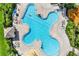 Aerial shot of a unique clover-shaped pool, lounge chairs, and splash pad at the neighborhood clubhouse at 11309 Langworth Hill Ln, Riverview, FL 33579