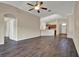 Open-concept living room with wood-look flooring, ceiling fan, and seamless flow into kitchen and dining area at 11309 Langworth Hill Ln, Riverview, FL 33579