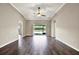 Bright and airy living room with sliding glass doors, vaulted ceilings, ceiling fan, and wood-look floors at 11309 Langworth Hill Ln, Riverview, FL 33579