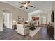 Spacious living room featuring a ceiling fan, hardwood floors, and an open layout to the kitchen area at 11309 Langworth Hill Ln, Riverview, FL 33579
