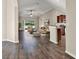 Bright open-concept living room with hardwood floors, ceiling fan, and bar top overlooking the kitchen at 11309 Langworth Hill Ln, Riverview, FL 33579