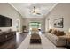 Bright living room boasts hardwood floors, vaulted ceilings, ceiling fan, and sliding glass doors to a patio at 11309 Langworth Hill Ln, Riverview, FL 33579