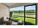 Screened patio with seating offers tranquil views of the lake and lush green surroundings at 11309 Langworth Hill Ln, Riverview, FL 33579