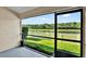 Tranquil patio view overlooking a lush lawn, a serene lake, and a tree line at 11309 Langworth Hill Ln, Riverview, FL 33579