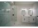 Bright bathroom features double vanity, framed mirrors and glass enclosed shower with marble tile at 11403 Wellman Dr, Riverview, FL 33578