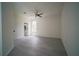 A bedroom with gray vinyl floors, modern ceiling fan, window view to the street, and attached bathroom at 11403 Wellman Dr, Riverview, FL 33578