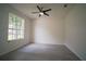 Bedroom featuring gray vinyl floors, modern ceiling fan, and a large window view to the street at 11403 Wellman Dr, Riverview, FL 33578