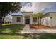 Inviting single-story home with fresh exterior paint, a well-kept lawn, and decorative landscaping at 11403 Wellman Dr, Riverview, FL 33578