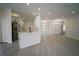Bright, open-concept living area with modern gray flooring, updated lighting, and a seamless flow to the kitchen at 11403 Wellman Dr, Riverview, FL 33578