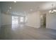 Expansive living room with gray flooring, recessed lighting, and a seamless transition to the outdoor pool area at 11403 Wellman Dr, Riverview, FL 33578