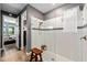 Contemporary bathroom showcasing a glass-enclosed shower, white tile, and wood floors at 11714 Tetrafin Dr, Riverview, FL 33579