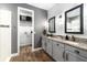 Bathroom featuring double sinks, granite countertops, gray cabinetry, and wood-look flooring at 11714 Tetrafin Dr, Riverview, FL 33579
