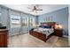A well-lit primary bedroom with a king-sized bed, wood floors, and scenic views of the lake at 11714 Tetrafin Dr, Riverview, FL 33579