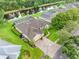 Aerial view of home with mature landscaping, a long driveway, and a nearby pond at 12439 Bristol Commons Cir, Tampa, FL 33626