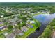 Aerial view showcasing lakefront homes with lush surroundings and serene lake; perfect blend of comfort and nature at 12439 Bristol Commons Cir, Tampa, FL 33626