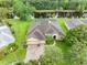 Aerial view of home with mature landscaping, paver driveway, pond, and solar panels at 12439 Bristol Commons Cir, Tampa, FL 33626