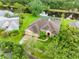 Aerial view of home with mature landscaping, a paver driveway, and a nearby pond at 12439 Bristol Commons Cir, Tampa, FL 33626