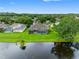 Aerial view of a landscaped backyard with a screened-in pool, and a pond at 12439 Bristol Commons Cir, Tampa, FL 33626