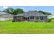 Backyard featuring a large screened-in patio, pool and lush green lawn at 12439 Bristol Commons Cir, Tampa, FL 33626