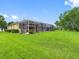 Spacious backyard showcasing a screened-in lanai and lush landscaping, offering serene outdoor living at 12439 Bristol Commons Cir, Tampa, FL 33626