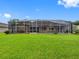 Large, well-maintained backyard with a screened-in lanai, ideal for relaxation and outdoor dining at 12439 Bristol Commons Cir, Tampa, FL 33626