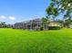 Expansive backyard with a screened-in lanai and a lush lawn, perfect for outdoor activities at 12439 Bristol Commons Cir, Tampa, FL 33626