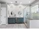 Bright bathroom featuring double sinks with decorative cabinets, a glass shower, and modern lighting at 12439 Bristol Commons Cir, Tampa, FL 33626