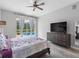 A primary bedroom featuring hardwood floors, a ceiling fan, and glass doors that lead to a pool area at 12439 Bristol Commons Cir, Tampa, FL 33626