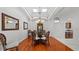 Elegant dining room with hardwood floors, decorative light fixture, and arched doorway at 12439 Bristol Commons Cir, Tampa, FL 33626