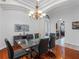 Bright dining room with modern glass table, hardwood floors, and view to adjacent rooms at 12439 Bristol Commons Cir, Tampa, FL 33626