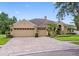 Lovely home featuring a paver driveway leading to a three-car garage and well-manicured landscaping at 12439 Bristol Commons Cir, Tampa, FL 33626