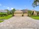 Exterior view of a three car garage and paved driveway of a single-Gathering home at 12439 Bristol Commons Cir, Tampa, FL 33626