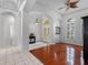 Spacious foyer with arched doorways, tile and wood flooring, and transom window above door at 12439 Bristol Commons Cir, Tampa, FL 33626