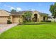 Charming home featuring a well-manicured lawn, mature landscaping, and a three-car garage at 12439 Bristol Commons Cir, Tampa, FL 33626