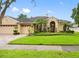 Charming home featuring a well-manicured lawn, mature landscaping, and a three-car garage at 12439 Bristol Commons Cir, Tampa, FL 33626