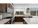 Well-lit kitchen featuring stainless steel appliances, quartz countertops, and backyard views at 12439 Bristol Commons Cir, Tampa, FL 33626