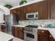 Modern kitchen boasts stainless steel appliances, tile backsplash, and dark wood cabinetry at 12439 Bristol Commons Cir, Tampa, FL 33626