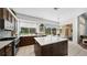 Bright kitchen featuring white countertops, dark wood island, and large windows overlooking the pool area at 12439 Bristol Commons Cir, Tampa, FL 33626