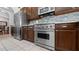Well-equipped kitchen with stainless steel appliances, tiled floor, and dark wood cabinets at 12439 Bristol Commons Cir, Tampa, FL 33626