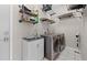 Modern laundry room equipped with washer, dryer and built-in shelving at 12439 Bristol Commons Cir, Tampa, FL 33626