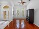 Bright living room with hardwood floors, ceiling fan, and natural light through arched windows at 12439 Bristol Commons Cir, Tampa, FL 33626