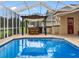 Screened-in patio with a pool and outdoor kitchen under a pergola at 12439 Bristol Commons Cir, Tampa, FL 33626